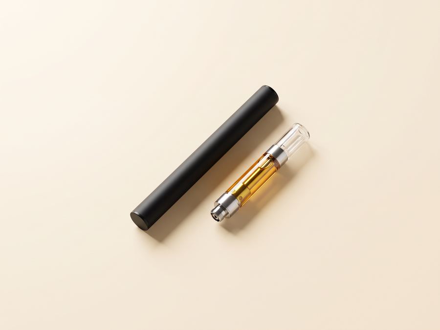A vape battery and a cartridge on a cream background