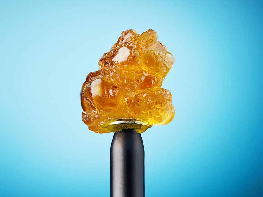 Amber live rosin concentrate against a light blue background