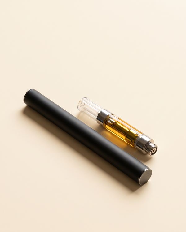 A vape battery and a cartridge on a cream background